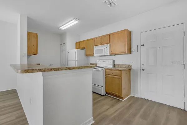 a kitchen with granite countertop a sink cabinets stainless steel appliances and a window