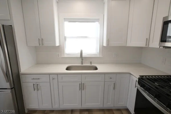a kitchen with white cabinets and a stove