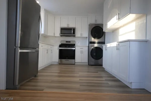 a kitchen with stainless steel appliances a stove microwave and sink