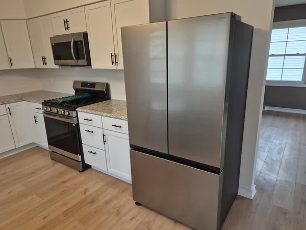 a kitchen with stainless steel appliances a refrigerator sink and microwave