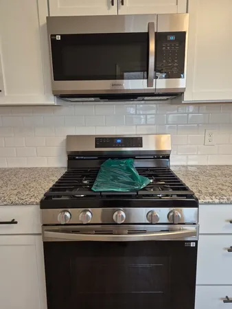 a stove top oven sitting inside of a kitchen