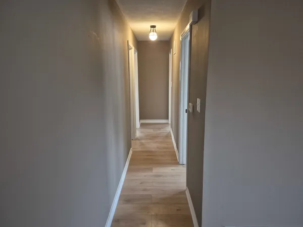 a view of a hallway with wooden floor