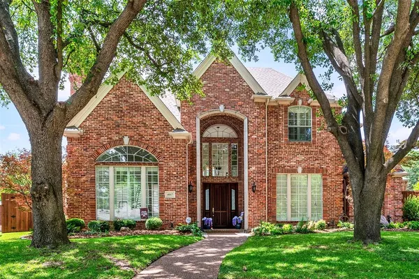 front view of a house with a tree and a yard