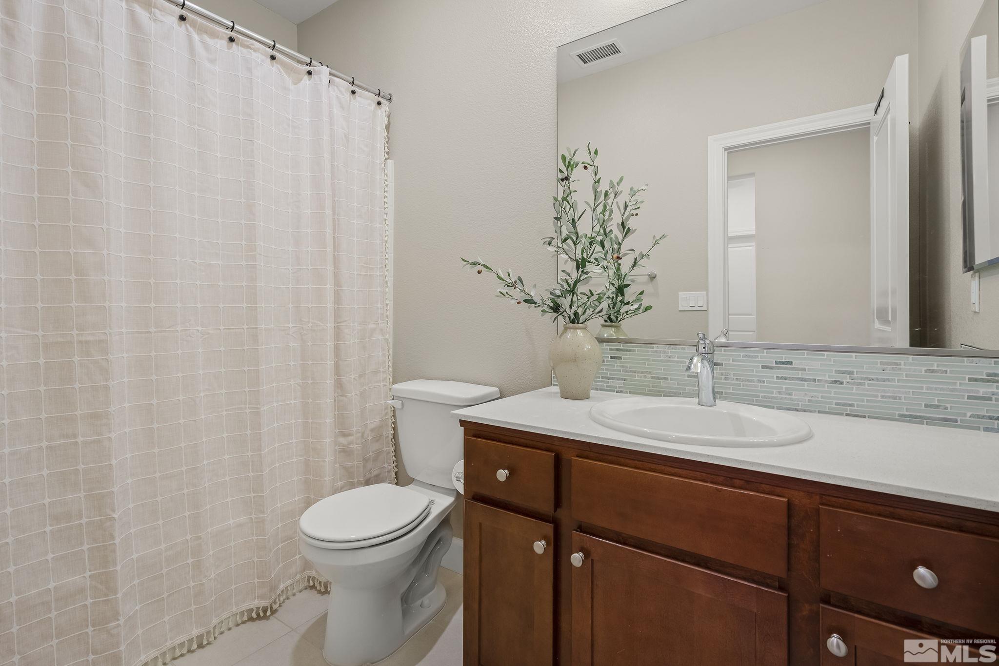 2041 Wind Ranch Road, Unit C Reno, NV 89521 - Photo 21 of 27 a bathroom with a granite countertop sink a toilet and a mirror