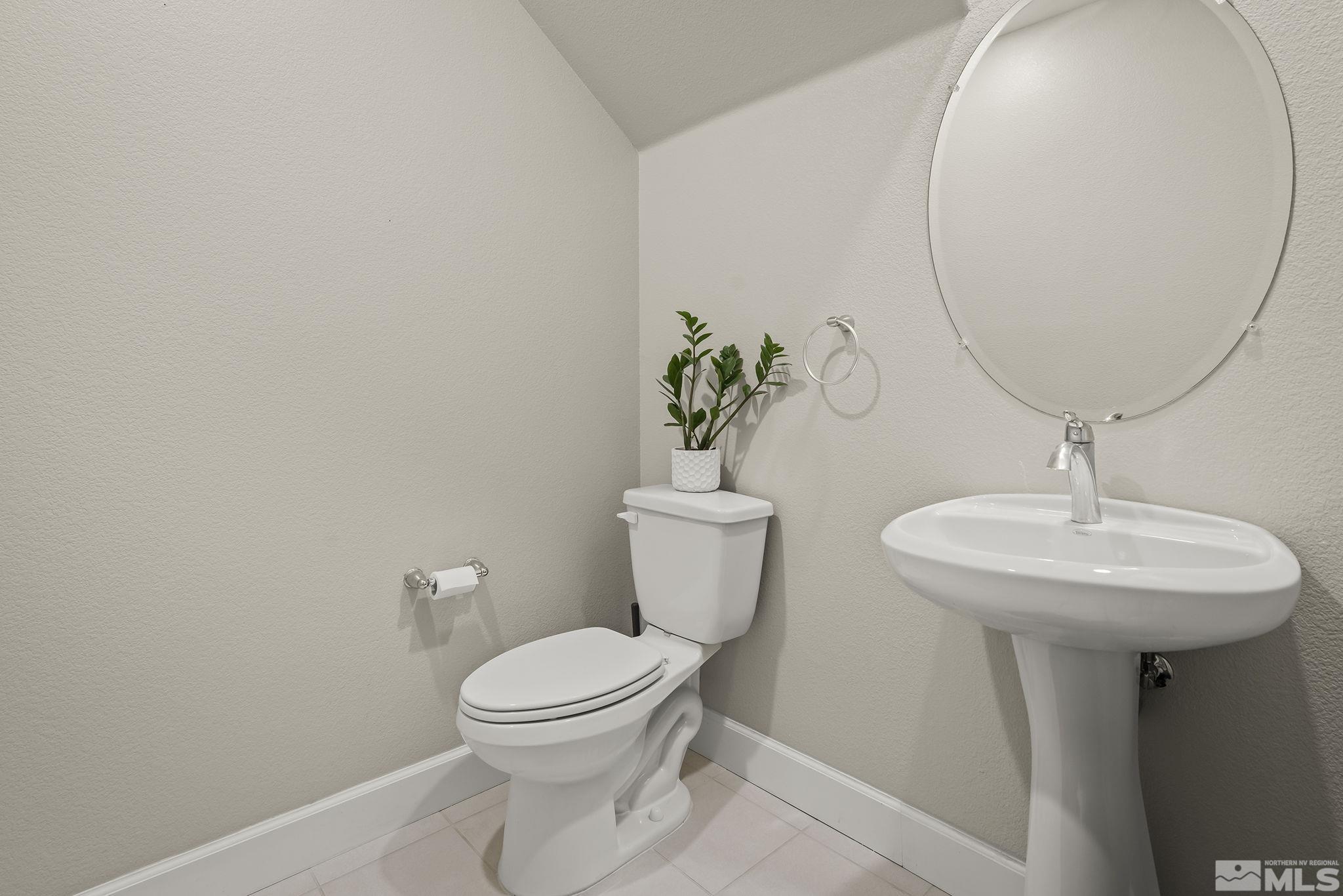 2041 Wind Ranch Road, Unit C Reno, NV 89521 - Photo 23 of 27 a bathroom with a toilet a sink and a mirror