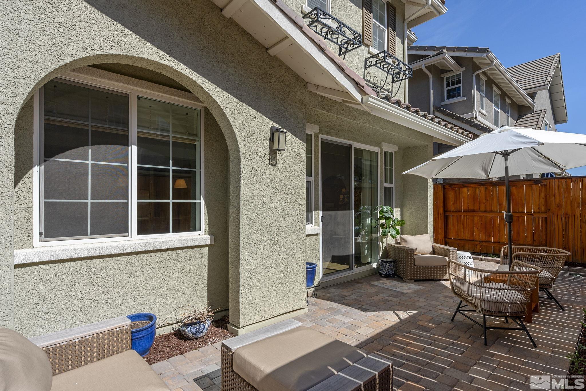 2041 Wind Ranch Road, Unit C Reno, NV 89521 - Photo 25 of 27 a view of a patio with table and chairs under an umbrella with a couch