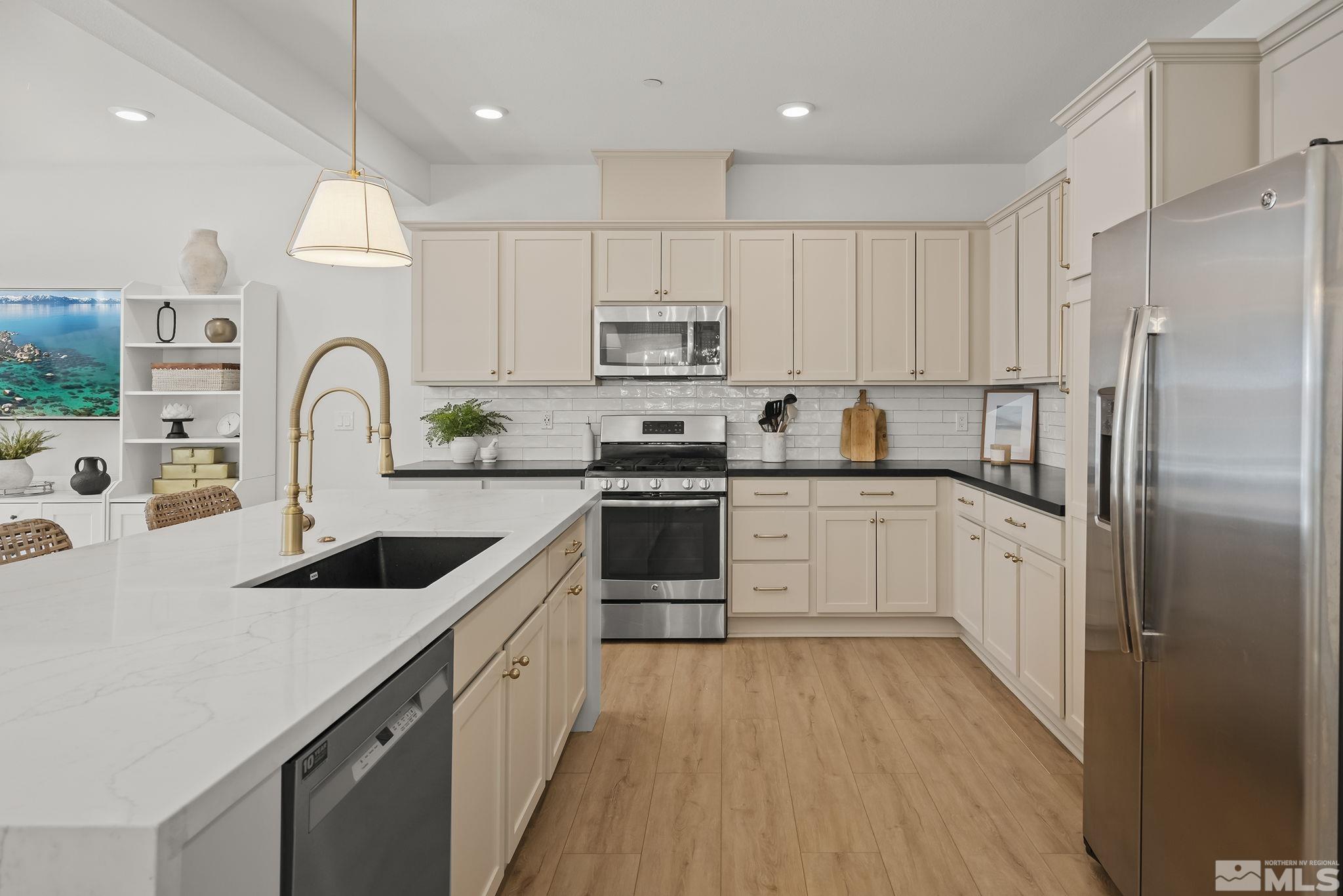 2041 Wind Ranch Road, Unit C Reno, NV 89521 - Photo 5 of 27 a kitchen with stainless steel appliances granite countertop a white cabinets a sink a stove a refrigerator and island with wooden floor