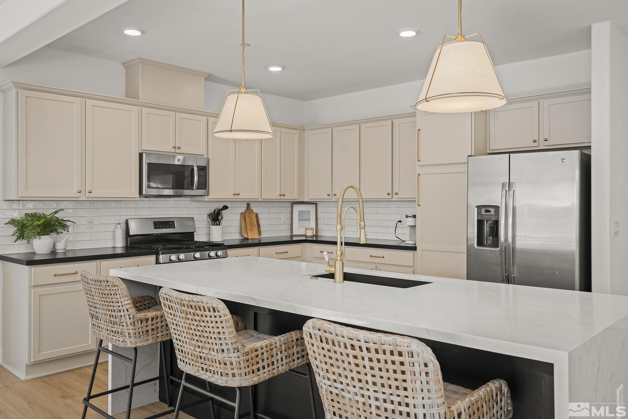 2041 Wind Ranch Road, Unit C Reno, NV 89521 - Photo 6 of 27 a kitchen with granite countertop a refrigerator a stove a sink and white cabinets