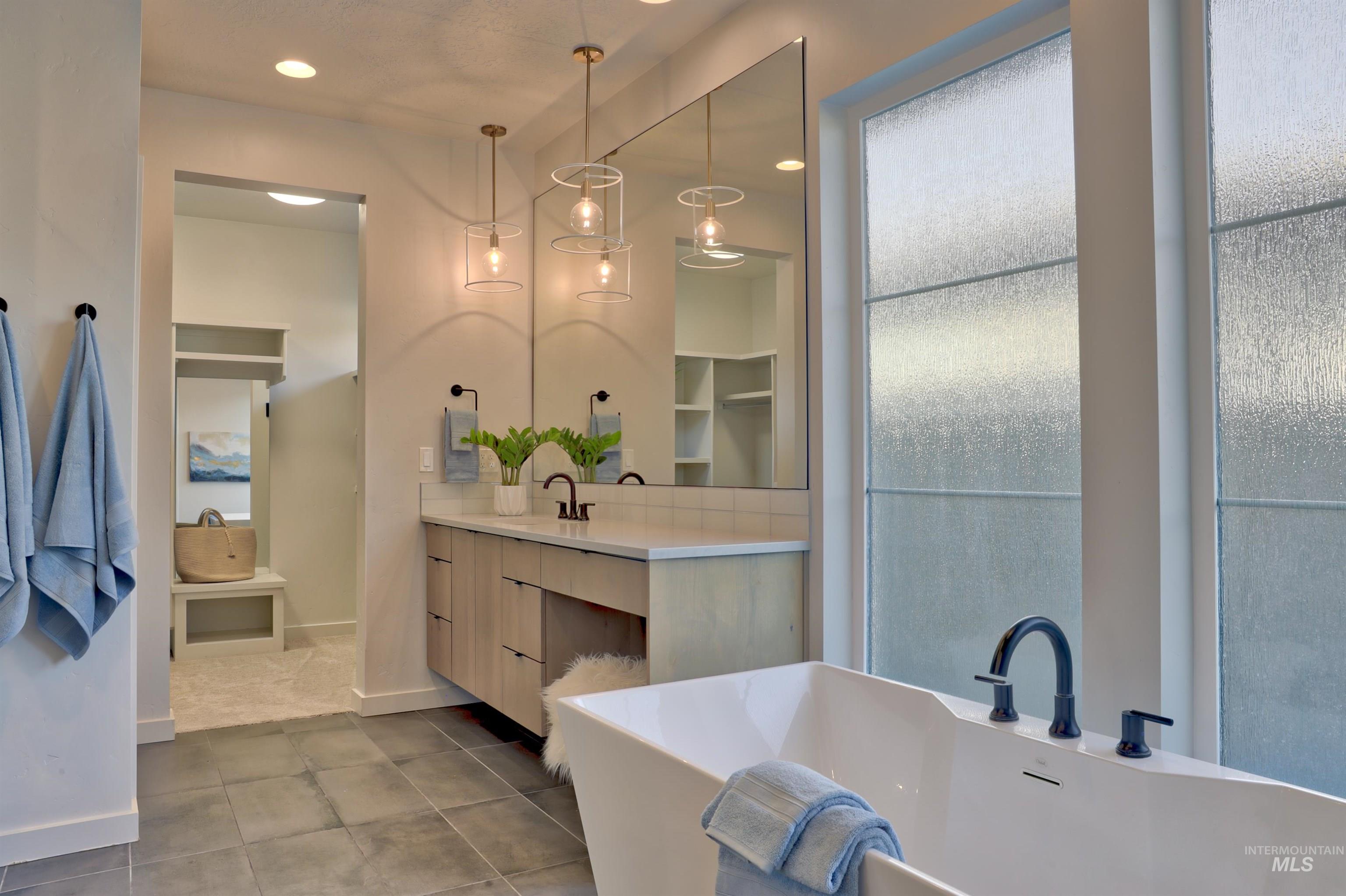 4148 East Copper Point Drive Meridian, ID 83642 - Photo 12 of 26 Full bath featuring vanity, a freestanding bath, recessed lighting, and tile patterned floors