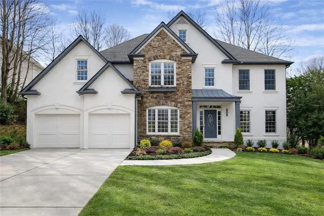 a front view of a house with a yard and garage