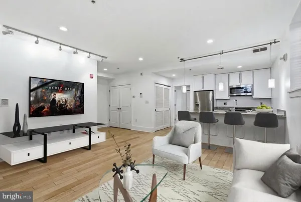 a living room with furniture kitchen view and a flat screen tv