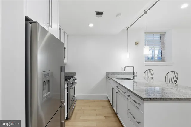 a kitchen with stainless steel appliances white cabinets and a stove top oven