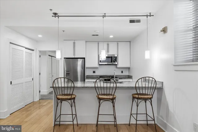 a kitchen with stainless steel appliances granite countertop a stove a refrigerator and a refrigerator