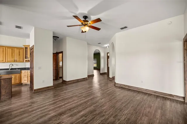 a view of a livingroom with wooden floor and a ceiling fan