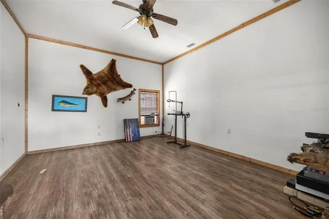 a view of a livingroom with wooden floor and a ceiling fan