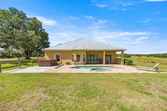 a view of a house with swimming pool and a yard