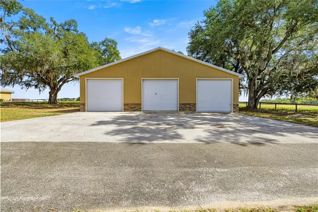 a view of a house with a yard and large trees