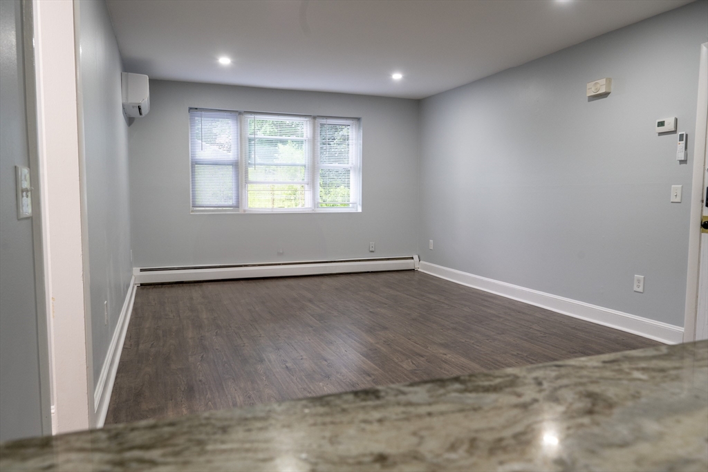225 South Main Street, Unit 7 Haverhill, MA 01835 - Photo 9 of 27 an empty room with wooden floor and windows
