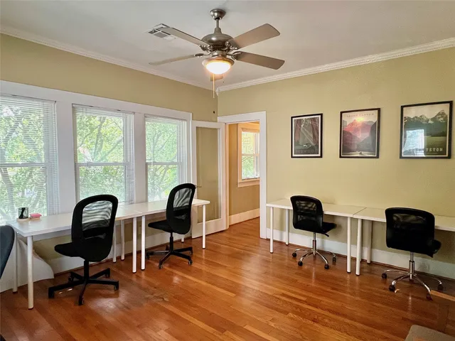 a view of a workspace with furniture and a window