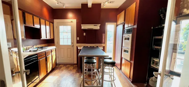 a kitchen with a sink stainless steel appliances a refrigerator and cabinets