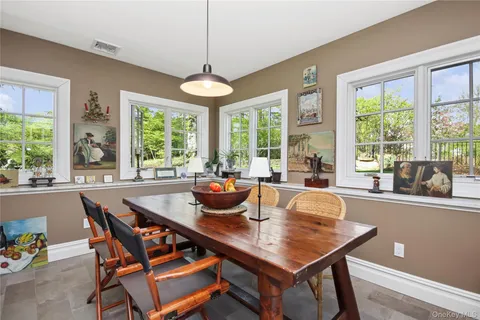 a dining room with furniture a chandelier and wooden floor