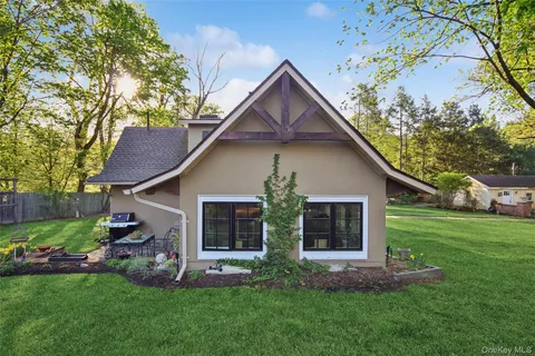 a front view of a house with a yard and trees