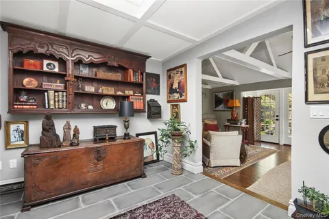 a living room with furniture a bookshelf and a window