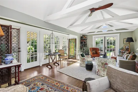 a living room with furniture a wooden floor and next to a window