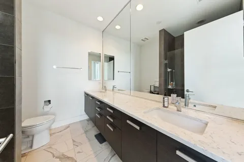 a bathroom with a double vanity sink mirror double and toilet