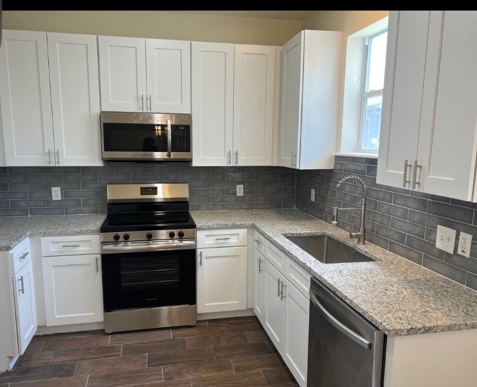 18713 Golden Eagle Way Elgin, TX 78621 - Photo 1 of 1 a kitchen with stainless steel appliances granite countertop a sink stove and cabinets