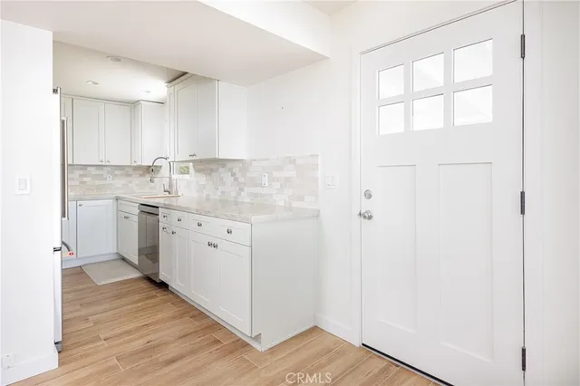 a kitchen with a sink cabinets stainless steel appliances and a window