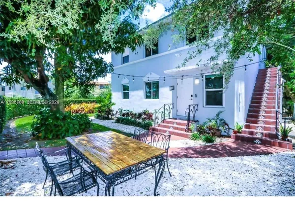 a view of a chair and table in backyard of the house