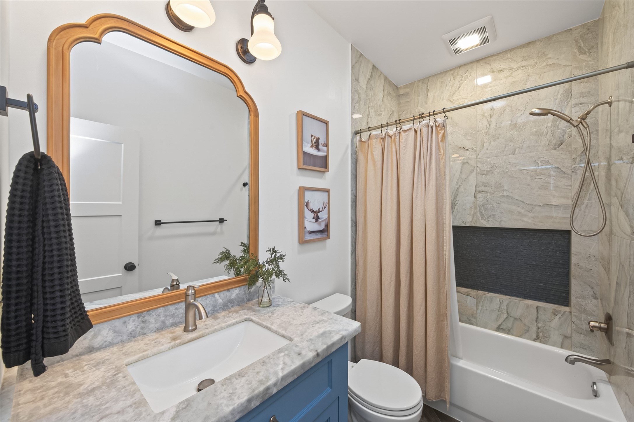 10 Belcarra Place Spring, TX 77382 - Photo 28 of 49 Secondary Bath w/custom built cabinetry w/natural stone counter & undermount sink. Designer vanity lighting & a solar tube to allow the natural light as well! Also features large format tile surround on the tub/shower combo that extends to the ceiling. Extra long shower niche provides lots of area to store your personal care items.