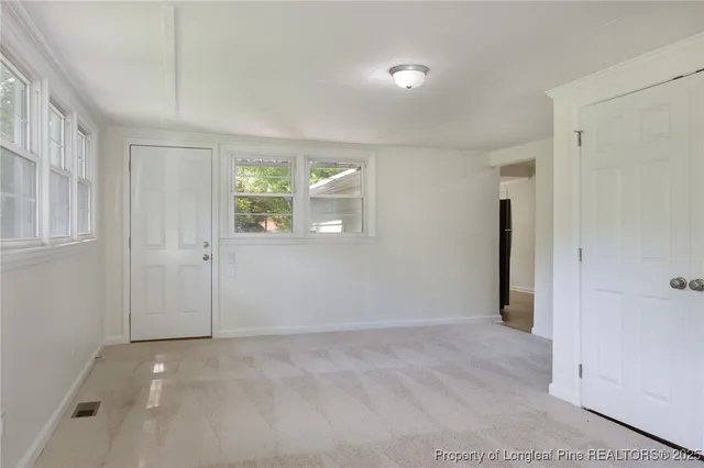 an empty room with windows and closet