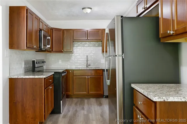 a kitchen with stainless steel appliances granite countertop a refrigerator and a sink