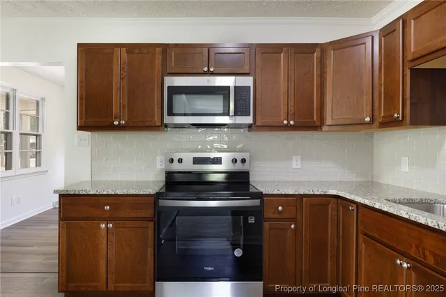a kitchen with stainless steel appliances granite countertop a stove a microwave and oven