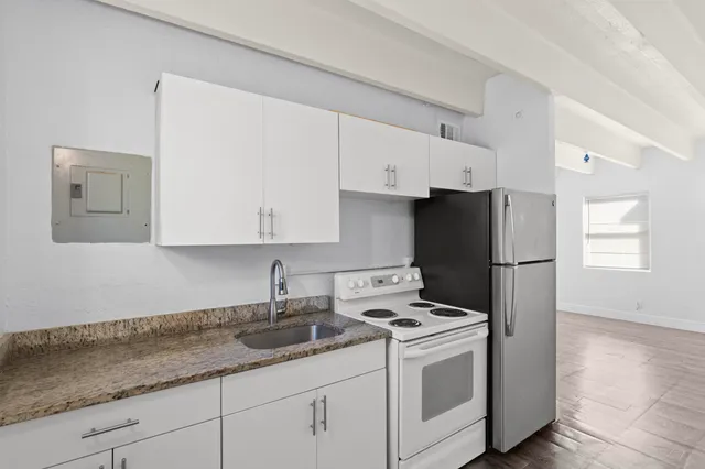 a kitchen with a sink a refrigerator and cabinets