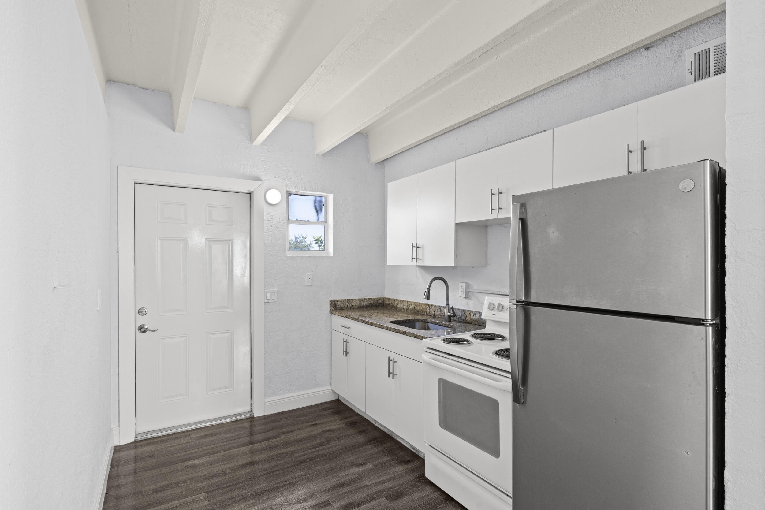 812 19th Street, Unit 3 West Palm Beach, FL 33407 - Photo 10 of 11 a kitchen with stainless steel appliances a refrigerator a sink and white cabinets