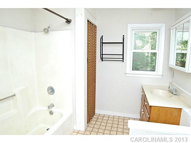 5413 Stone Mill Road Waxhaw, NC 28173 - Photo 14 of 16 a bathroom with a sink a mirror and a shower