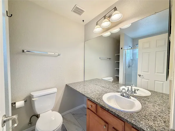 a bathroom with a granite countertop sink and a mirror
