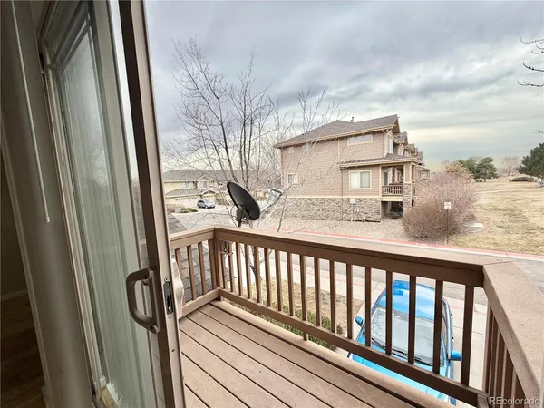a view of a balcony with wooden floor and fence