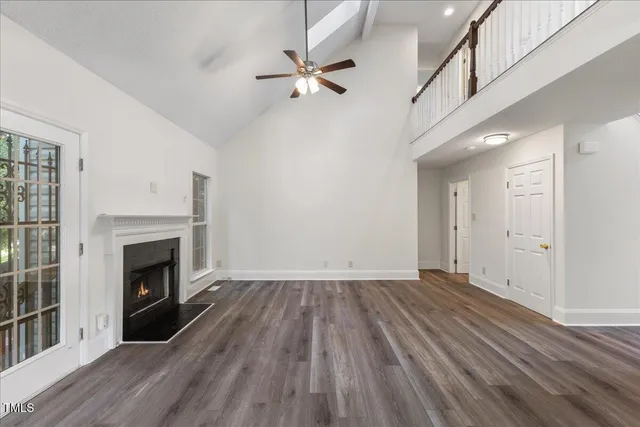 wooden floor fireplace and windows in an empty room
