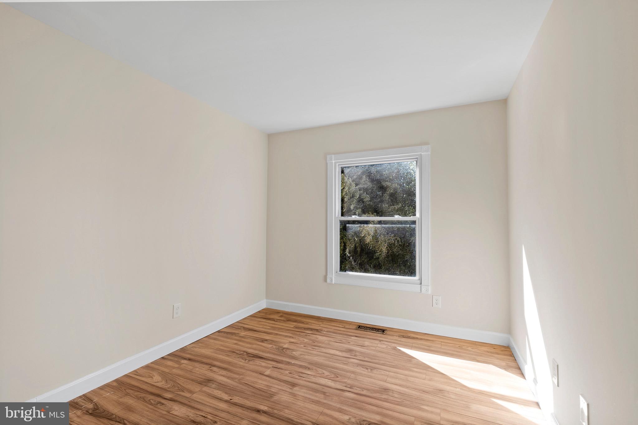 38 Deepspring Court Reisterstown, MD 21136 - Photo 8 of 17 a view of an empty room with wooden floor and a window