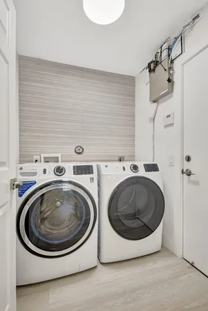 a kitchen with stainless steel appliances kitchen island granite countertop a table chairs in it and a wooden floor