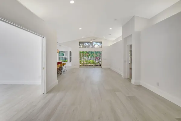 an empty room with large windows and garden