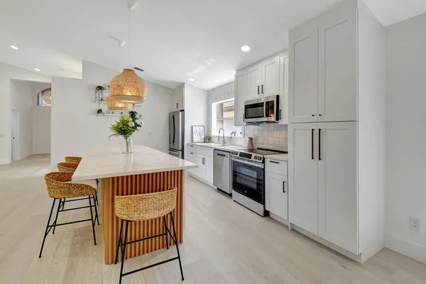 a front view of a house with a yard and trees