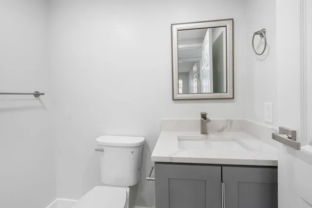 a bathroom with a toilet sink and mirror