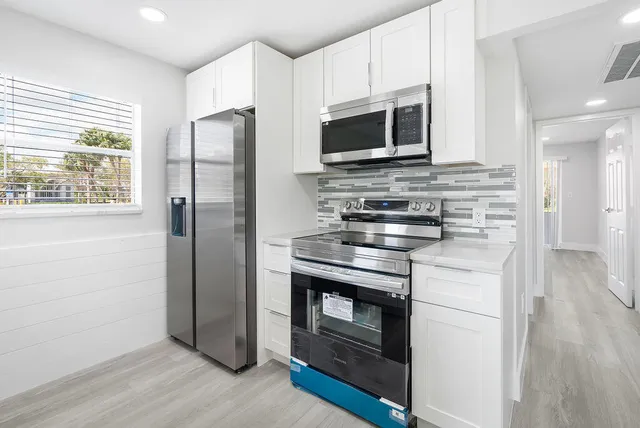 a kitchen with stainless steel appliances a stove microwave and a refrigerator