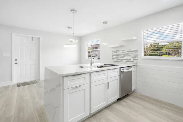 a kitchen with granite countertop white cabinets and white appliances