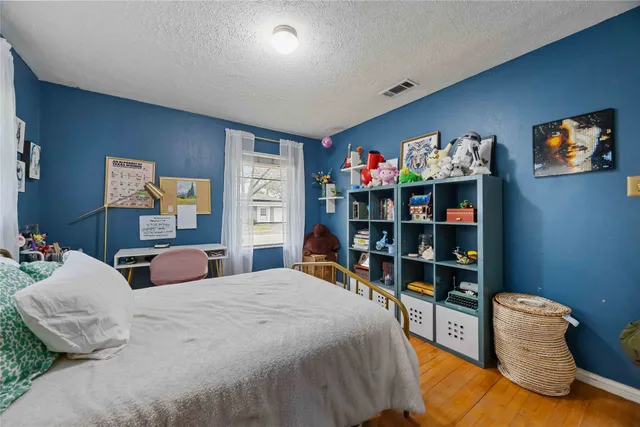 a bedroom with a bed and a dresser next to a window